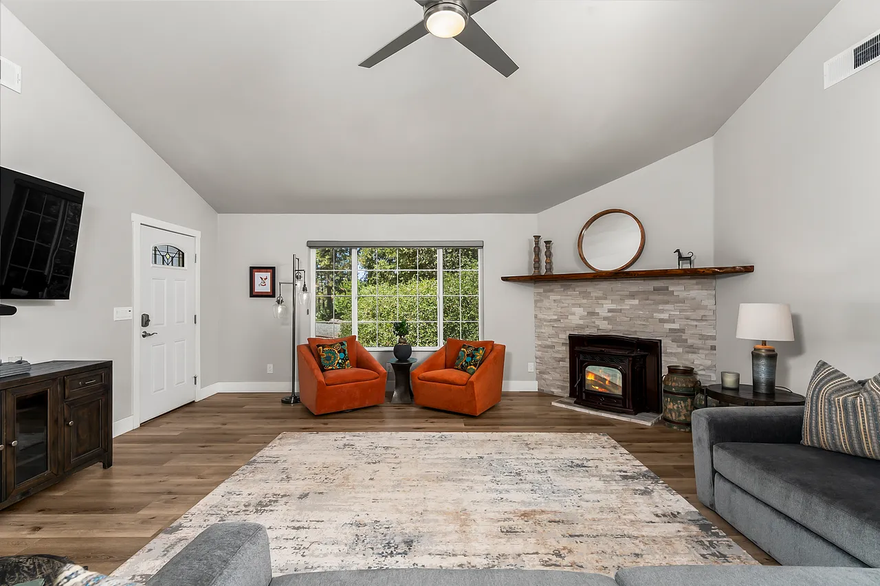 Open living room with vaulted ceilings, skylights and a pellet stove