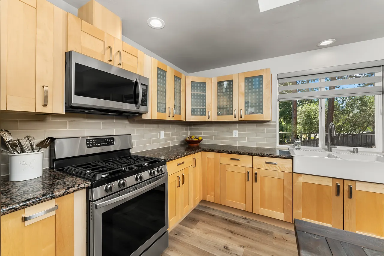 Chef's kitchen with granite counters, farmhouse sink and subway tile backsplash